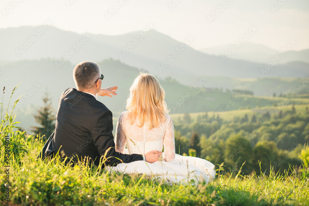 Groom shows bride the beautiful views of the mountains during honeymoon
