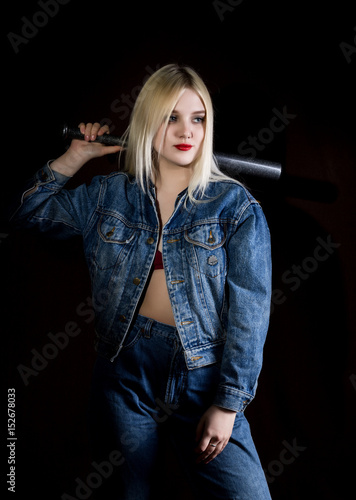 Fotografie Criminal young woman with baseball bat, young hooligan in jeans and a denim jack