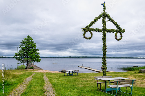 Tableau sur toile Midsummer maypole on the lake coast