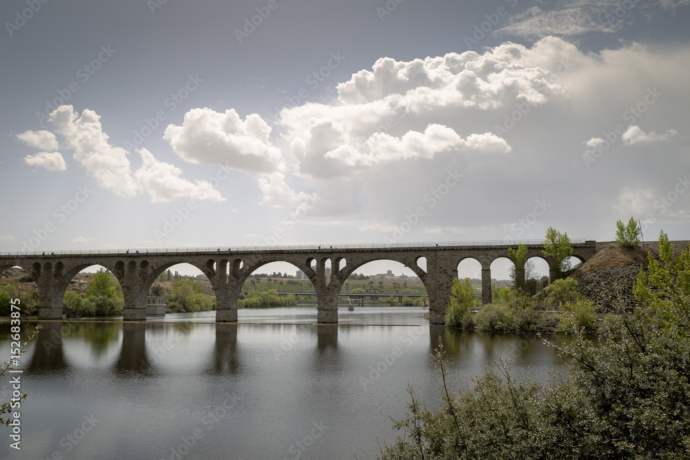 Old stone bridge for railroad crossing a dam next to a highway
Old stone bridge for railroad crossing a dam next to a highway