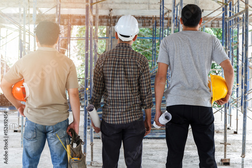 Engineer, foreman and worker discussing in building construction site © skarie