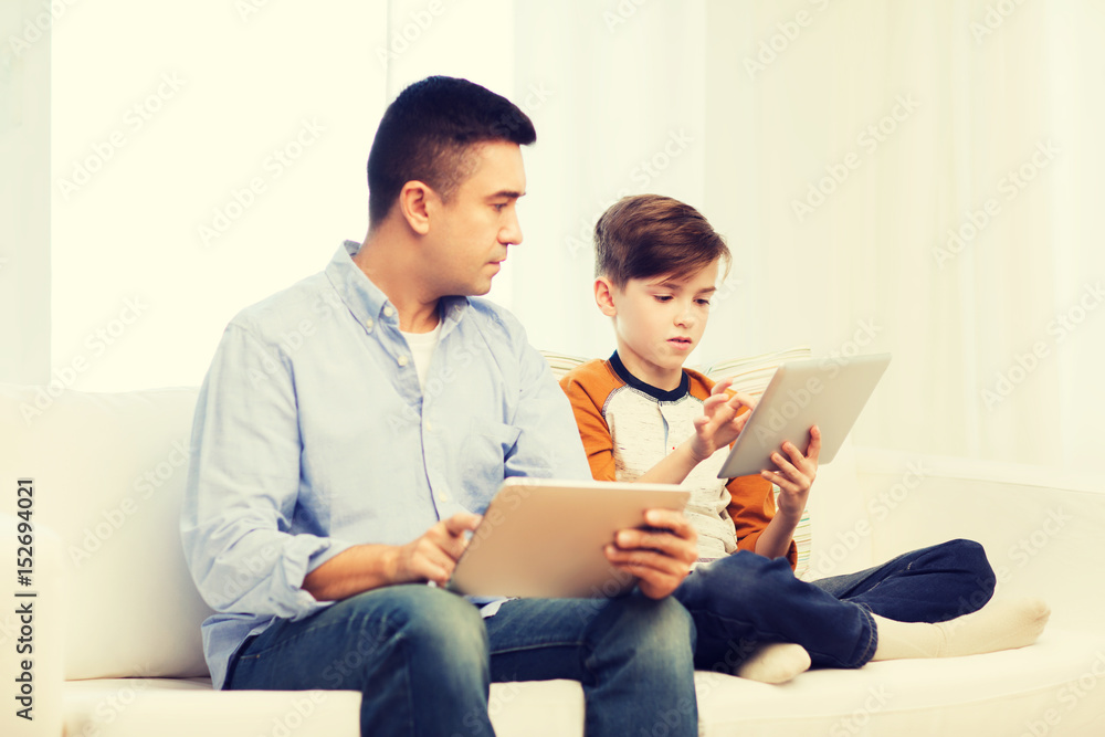 father and son with tablet pc at home father and son with tablet pc at home