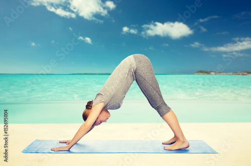 woman making yoga dog pose on mat