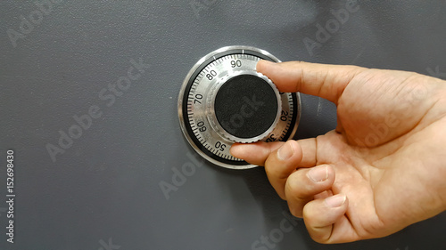  Close up of a safe lock and male hand conceptual image photo
