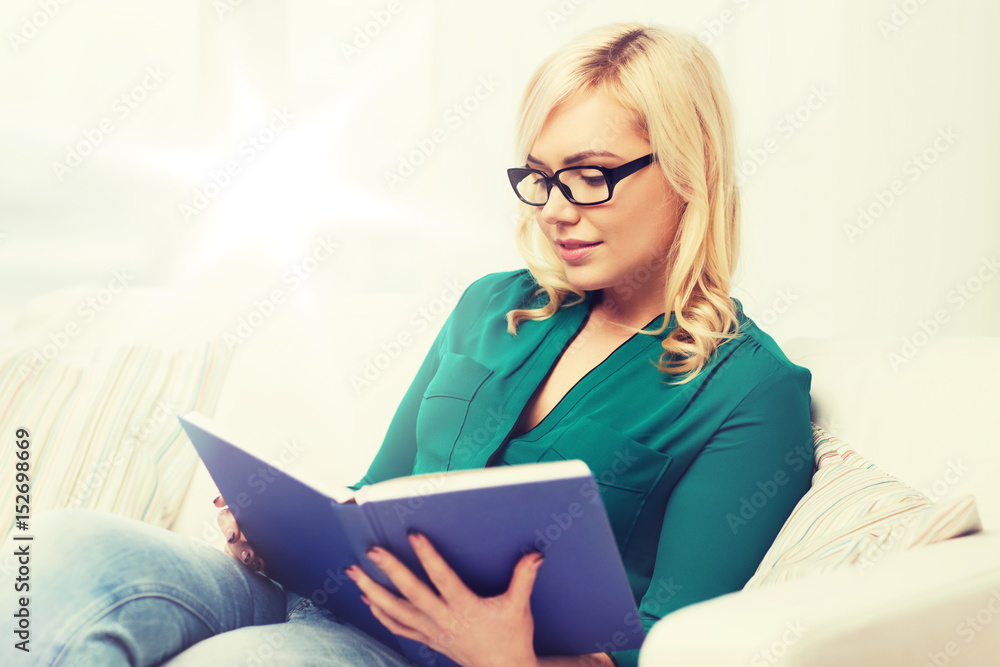young woman in glasses reading book at home young woman in glasses reading book at home