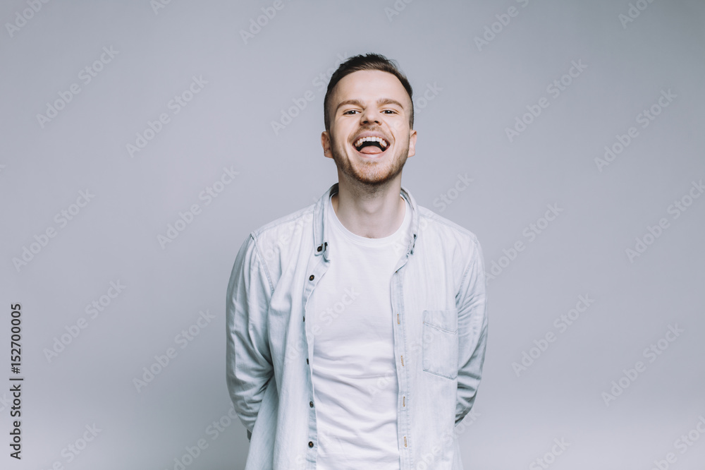Standing smiling young man with beard in a white shirt Standing smiling young man with beard in a white shirt