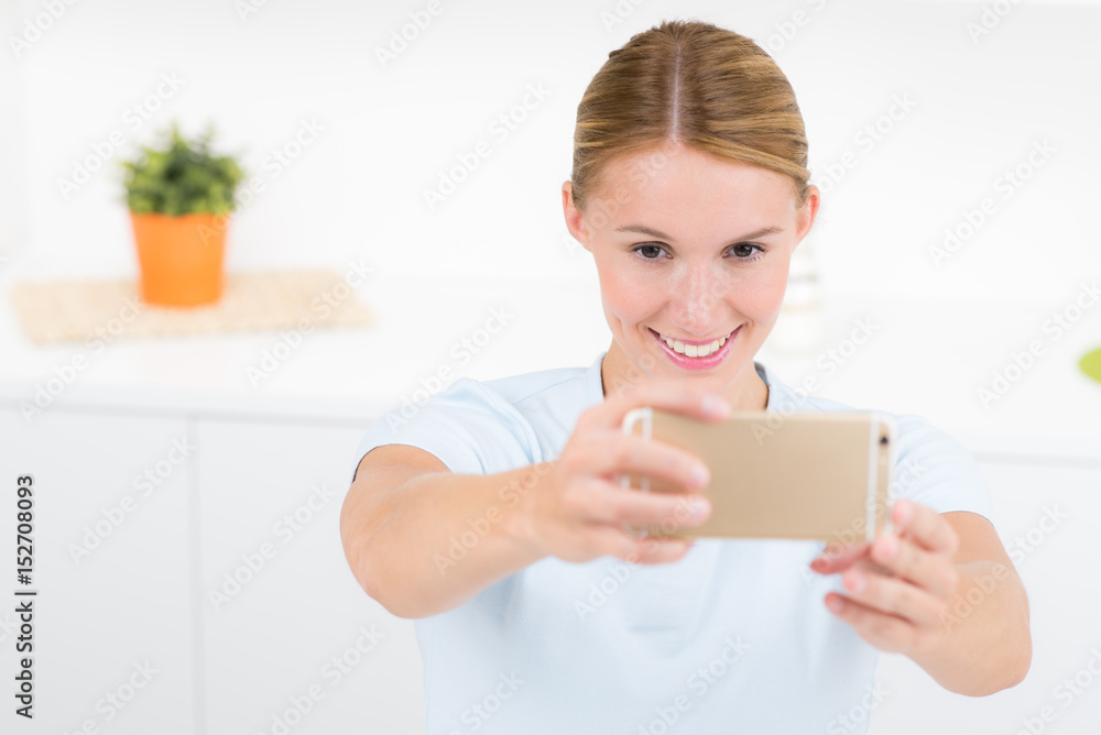 frau macht ein selfportrait mit dem smartphone frau macht ein selfportrait mit dem smartphone