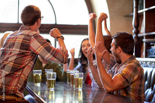 football fans or friends with beer at sport bar