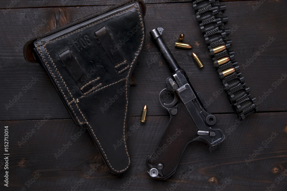 Gun Luger with cartridges and holster on the blackboard Gun Luger with cartridges and holster on the blackboard