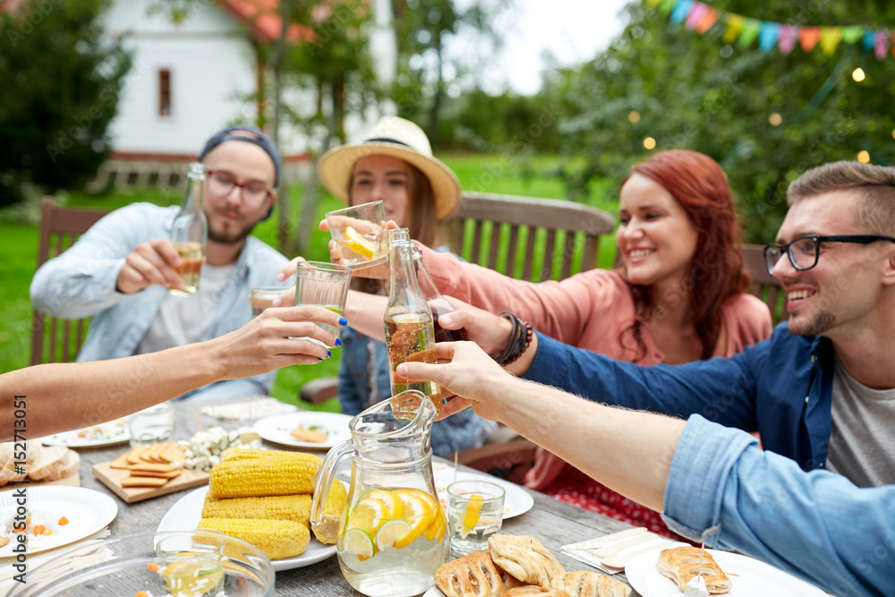 happy friends with drinks at summer garden party happy friends with drinks at summer garden party