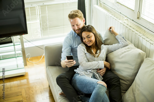 Loving couple in the room with mobile phone