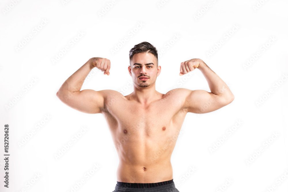 Shirtless fitness man flexing his arms. Studio shot. Shirtless fitness man flexing his arms. Studio shot.