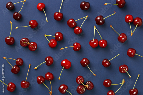 Cherry pattern. Flat lay of cherries on a dark blue background.Top view