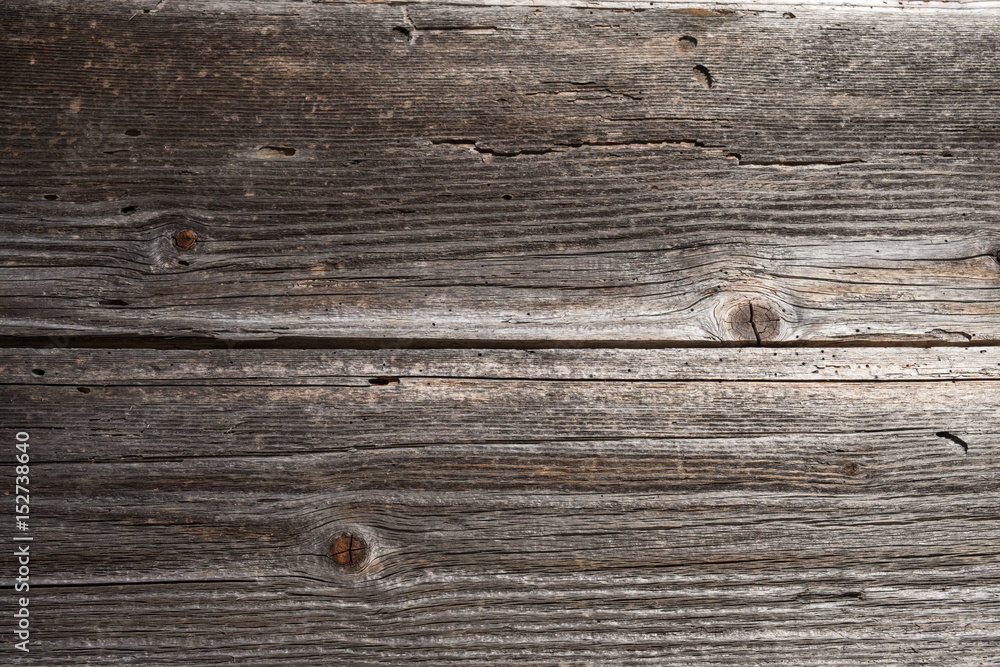 Fototapeta premium Two horizontal weathered timber planks on old wooden building with joint in the middle