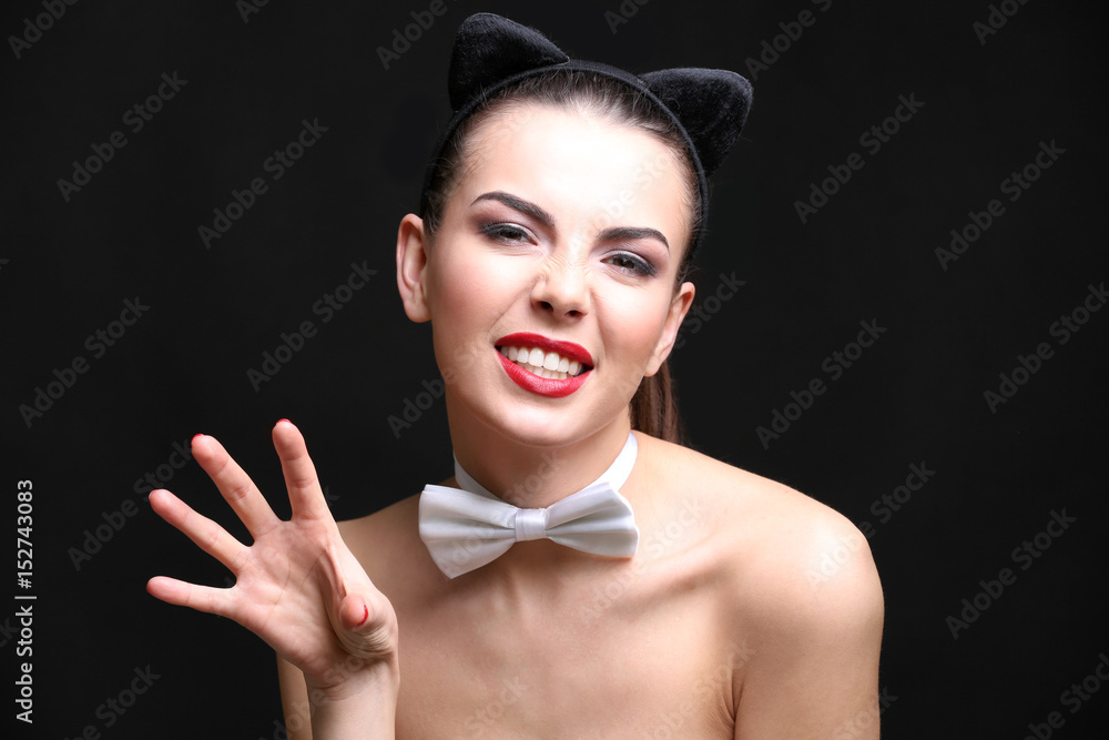 Sexy young woman wearing cat ears on black background Stock Photo