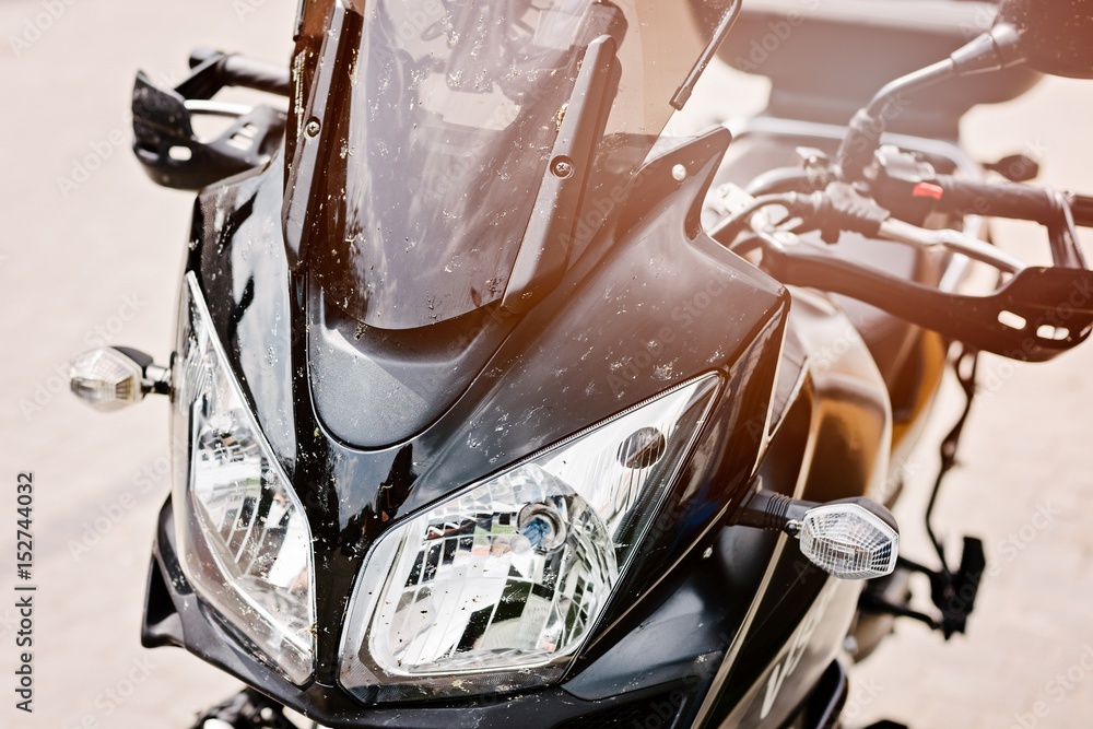 Black touristic motorbike dirty from insects