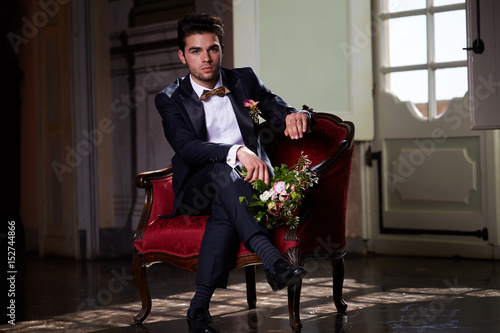 young groom waiting his bride on sofa photo