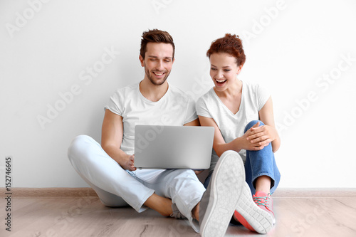 Happy young couple with lap...