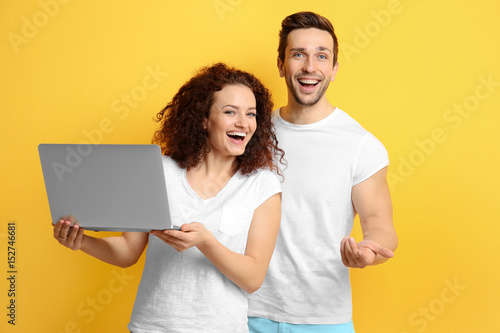 Happy young couple with lap...