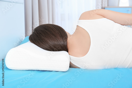 Young woman lying on bed wi...