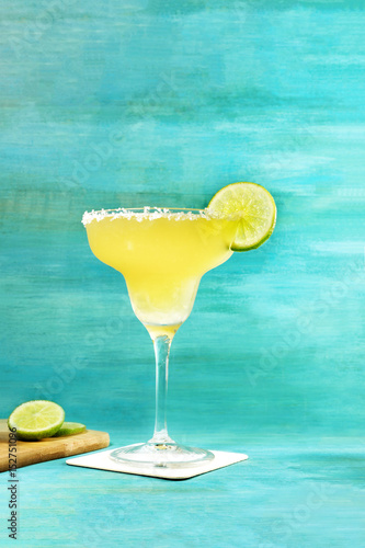 Lemon Margarita cocktail on vibrant turquoise with copyspace