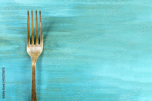Vintage fork on vibrant turquoise with copyspace
