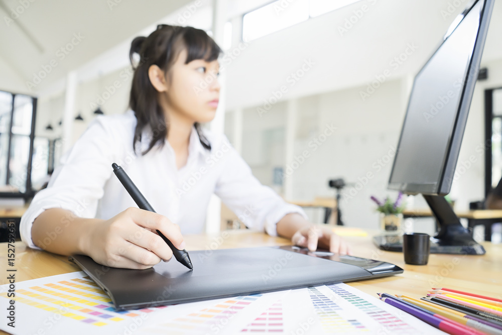 Graphic designer using graphics tablet and computer in the office Graphic designer using graphics tablet and computer in the office