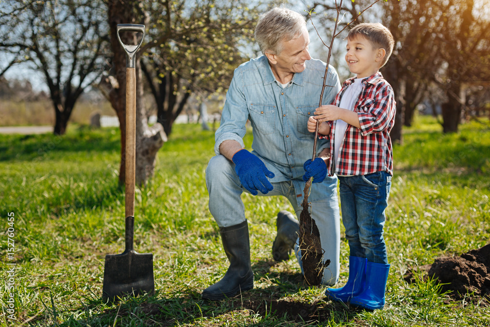 Grandfather with his grandson working in garden Grandfather with his grandson working in garden