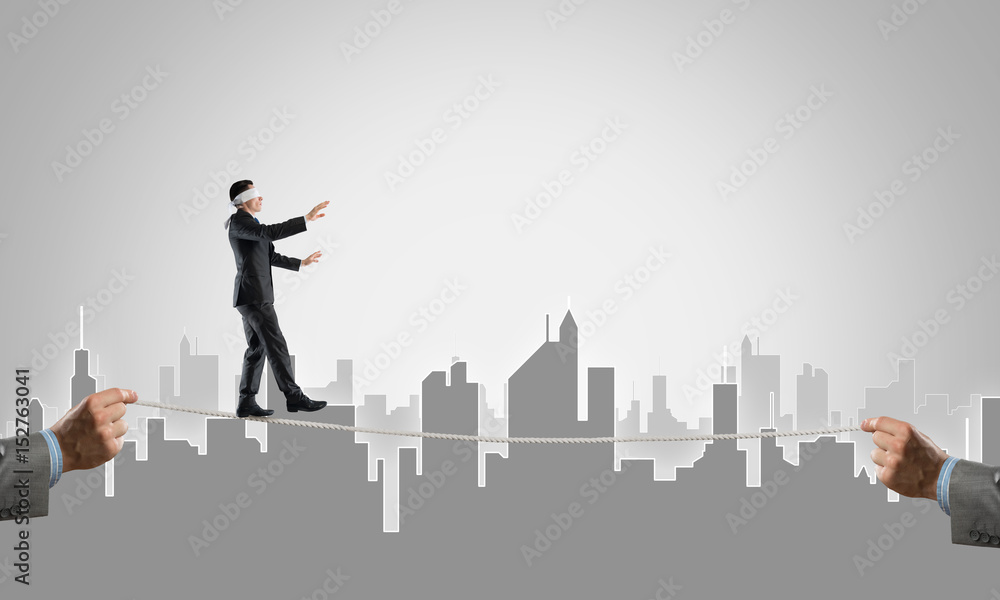 Business concept of risk support and assistance with man balancing on rope Business concept of risk support and assistance with man balancing on rope
