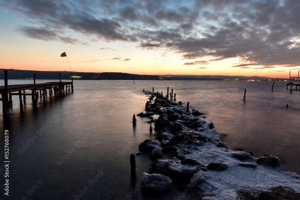 Fototapeta premium Cloudy sky and winter sea at the sundown