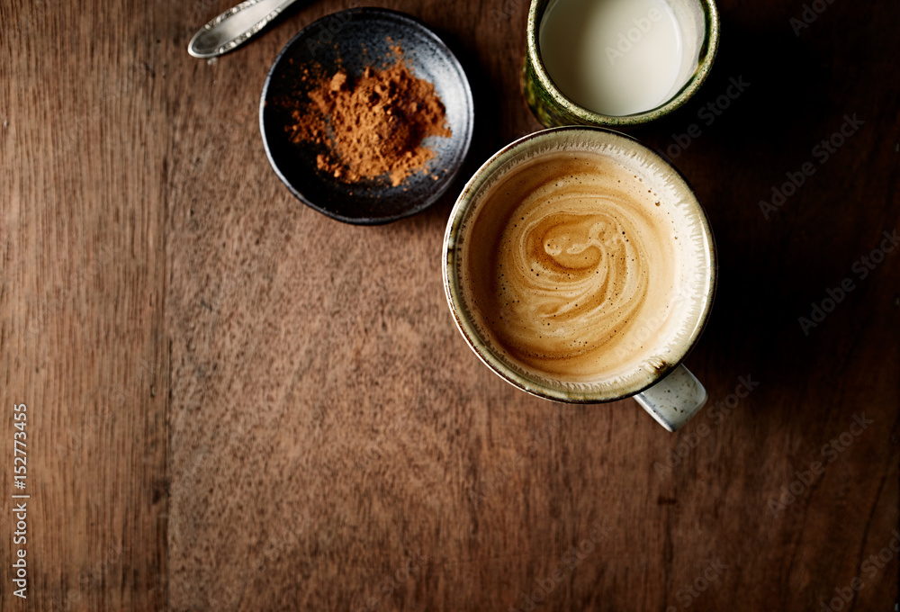 Mug of Coffee with Milk and Cinnamon on Wooden Table Mug of Coffee with Milk and Cinnamon on Wooden Table