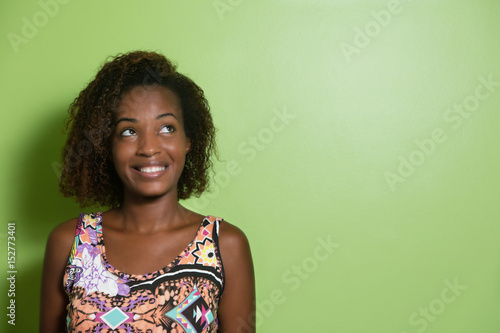 African american woman looking sideways to a green wall © Daniel Ernst