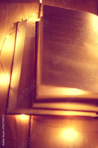 stack of books with open pages on a wooden table.Soft warm light .  Defocus