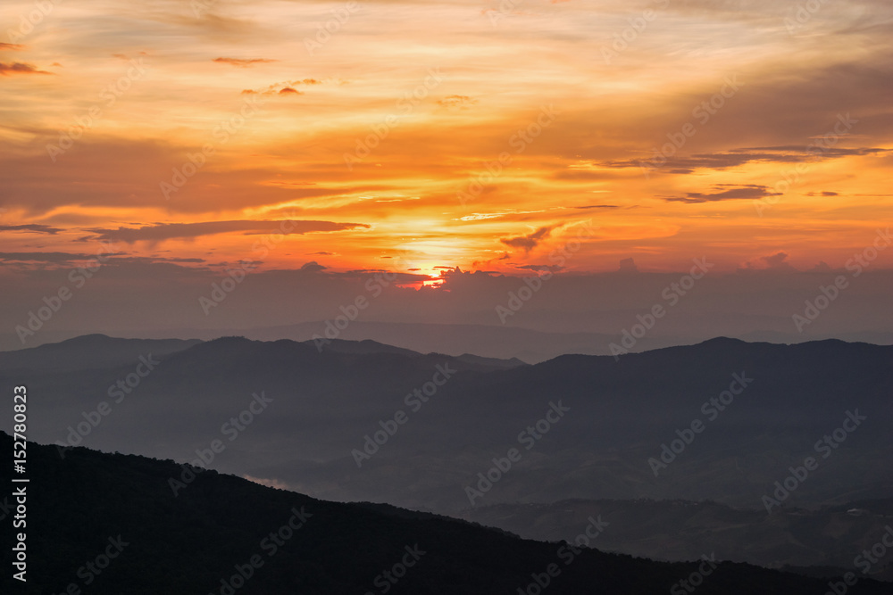 Fototapeta premium Piękna przyroda krajobraz na górze z mgły chmury słońca i jasne kolory nieba i słońca podczas zachodu słońca w zimie w punkcie widzenia Phu Chi Fa Forest Park w prowincji Chiang Rai, Tajlandia