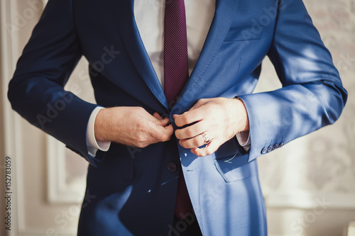 Man buttoning his jacket © artem_goncharov