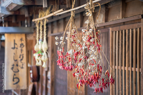 Traditional Japanese red chillies hanging from thatched roof photo