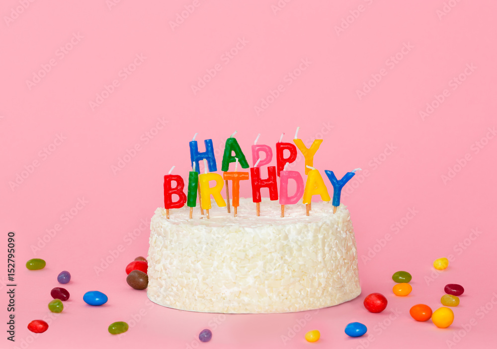 Happy birthday cake with color candles on pink background Happy birthday cake with color candles on pink background