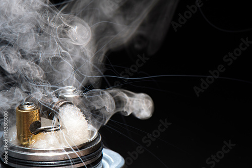 flying mod with a driptip light smoke on a black background for vaping diffused photo