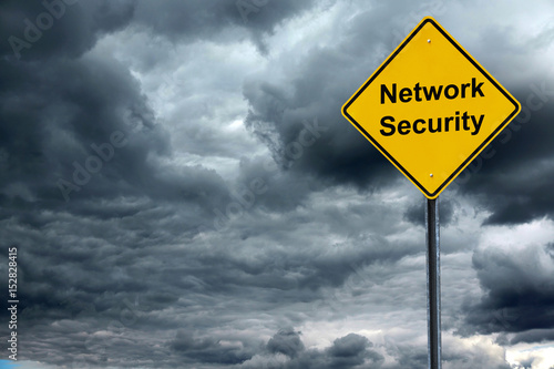 network security text on the warning sign in front of storm cloud