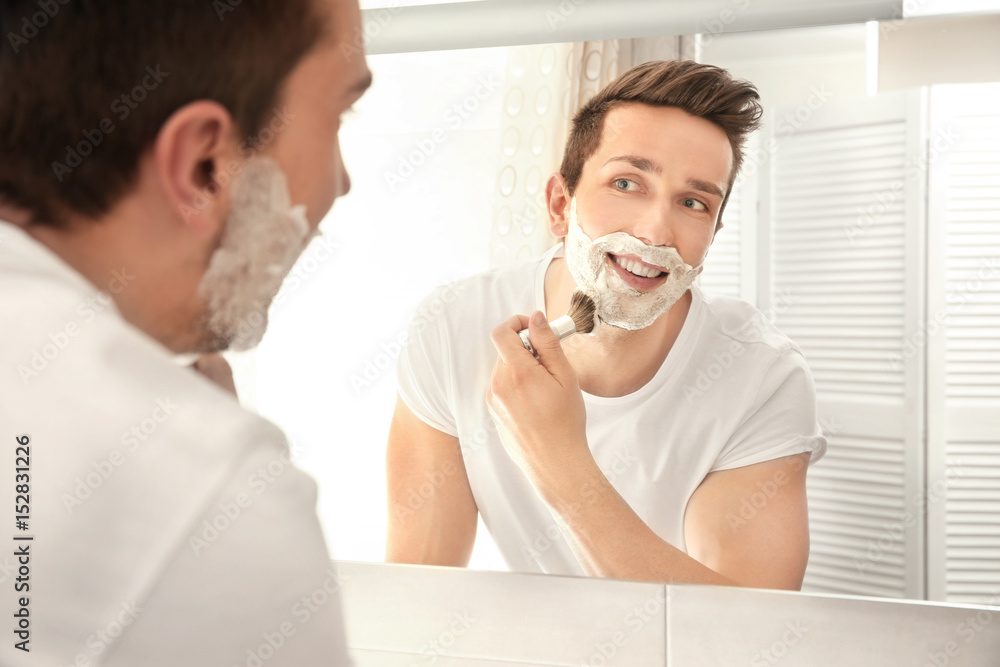 Handsome man shaving in bathroom Handsome man shaving in bathroom