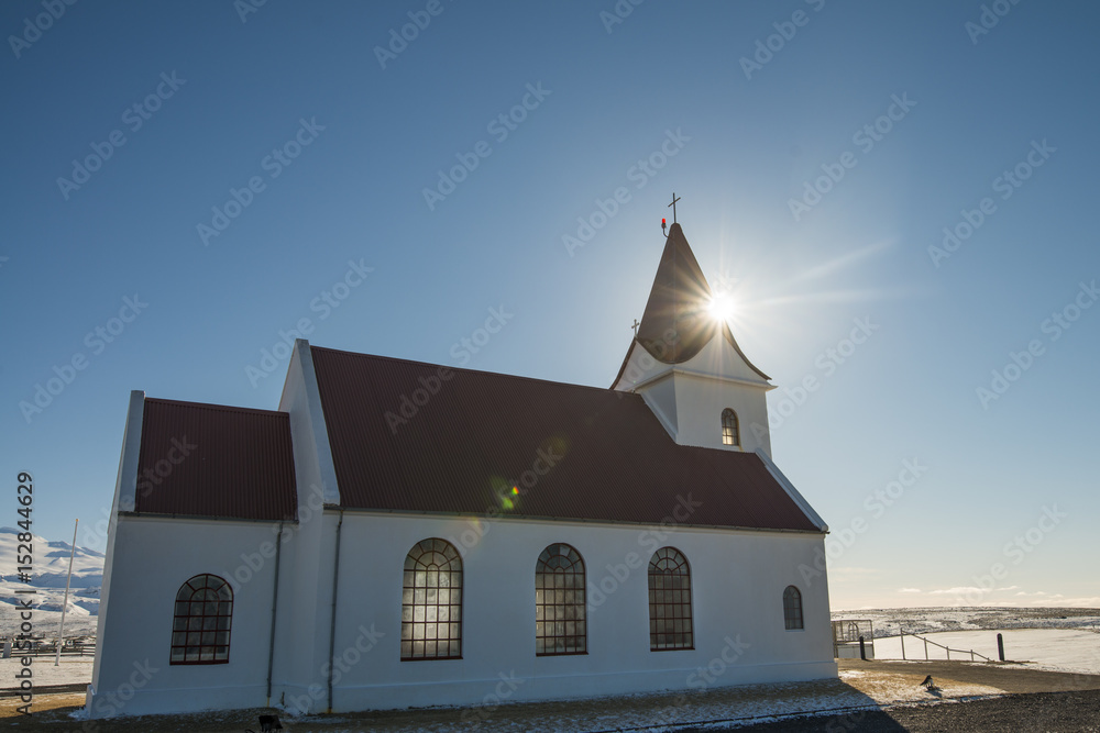Hillside White Church with sunflare