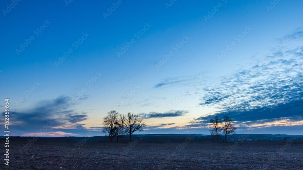 Beautiful colorful sunset sky over plowed field in springtime Beautiful colorful sunset sky over plowed field in springtime