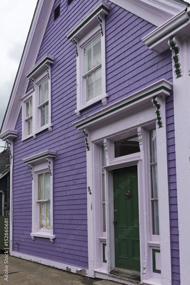 Green door with white frame, and lilac colored walls in Lunenburg, Nova Scotia, Canada