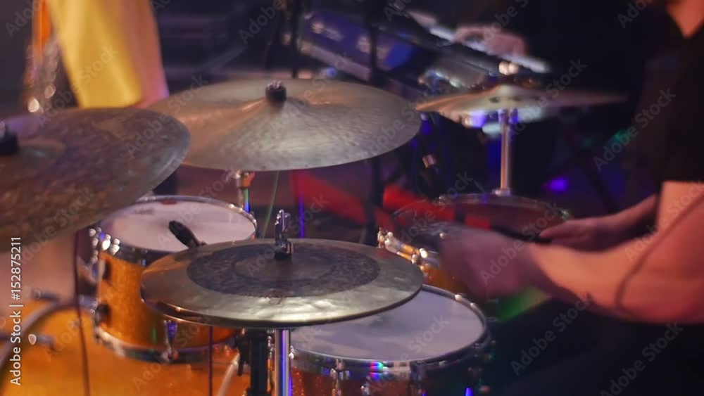 Musical Band Performs at a Night Concert, One Man Plays a Drum Set Another Sings and a Third Keyboard Player in the Background Musical Band Performs at a Night Concert, One Man Plays a Drum Set Another Sings and a Third Keyboard Player in the Background