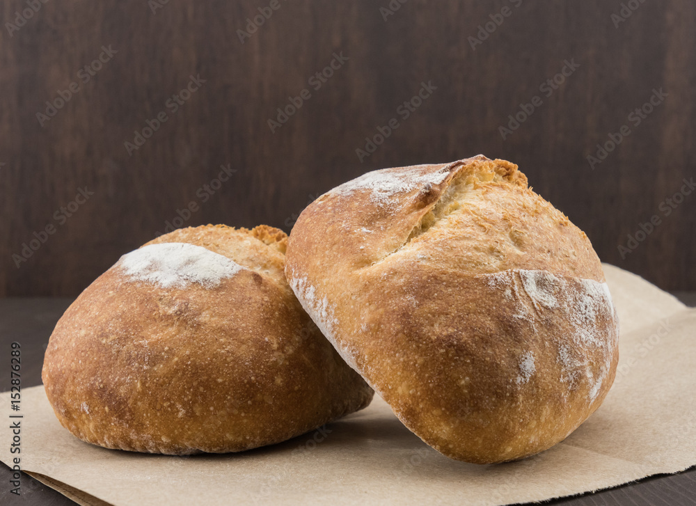 Two Dinner Rolls on Brown Paper