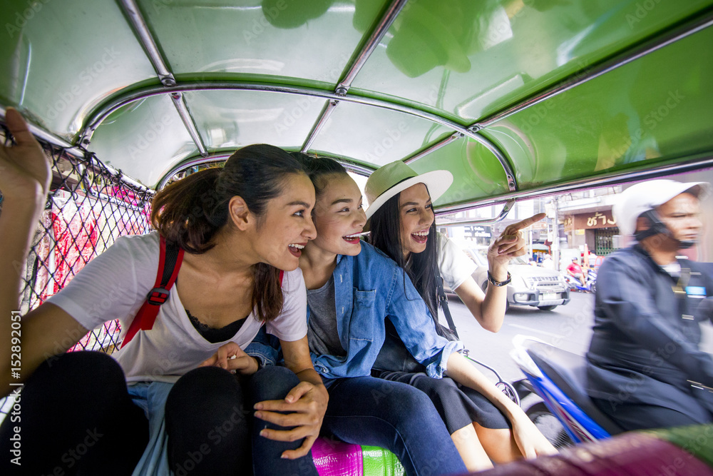 Obraz premium Three asian girls are exploring Chinatown, Thailand by Tuk tuk