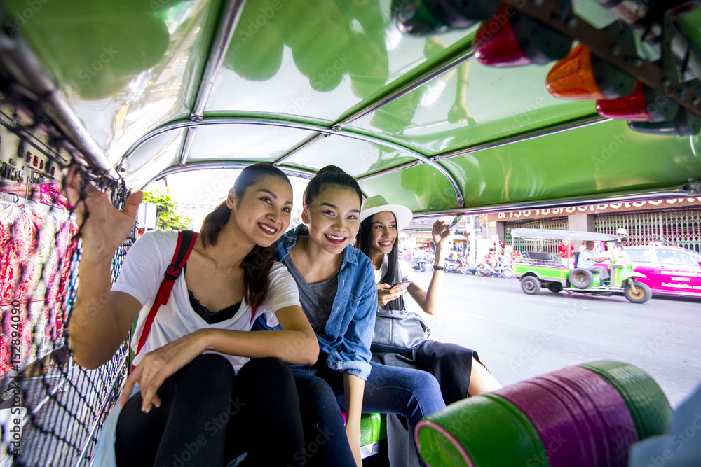 Fototapeta premium Three asian girls are exploring Chinatown, Thailand by Tuk tuk