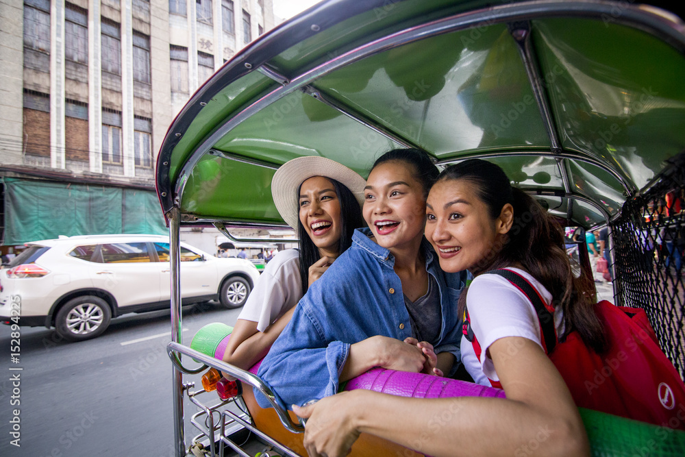 Fototapeta premium Three asian girls are exploring Chinatown, Thailand by Tuk tuk