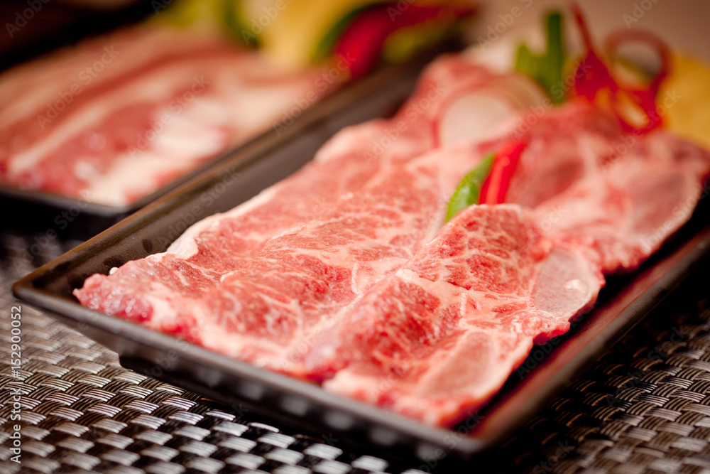 Fresh raw sliced beef with chili on black tray Fresh raw sliced beef with chili on black tray