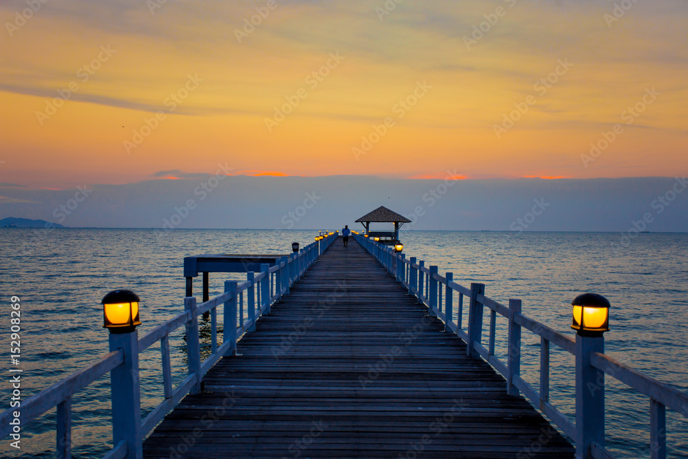 The wooden bridge on sea at sunset, Thailand.